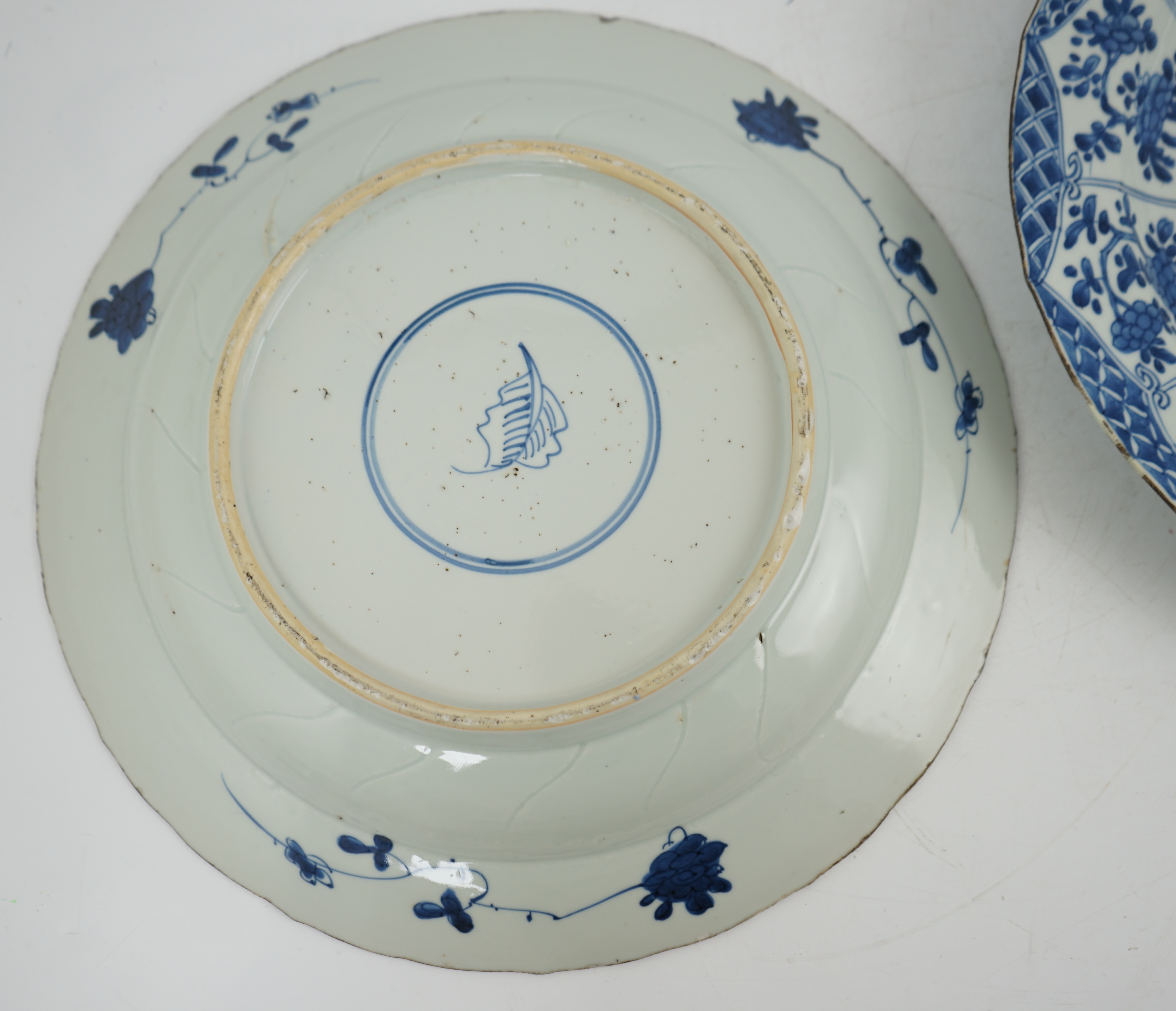 A pair of Chinese blue and white ‘garden’ dishes, Kangxi period, fritting and glaze chips